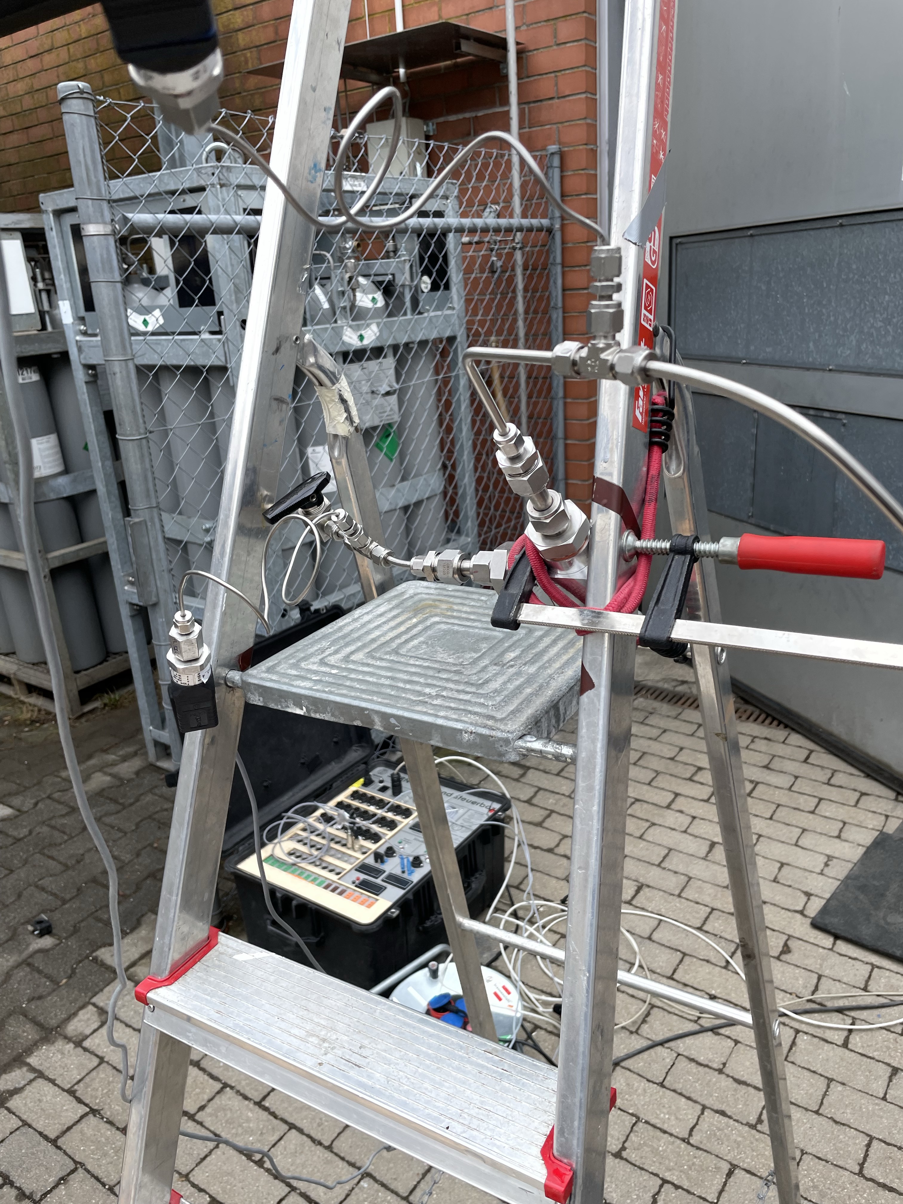 Outdoor test setup for high-pressure valve testing with instrumentation and safety cage